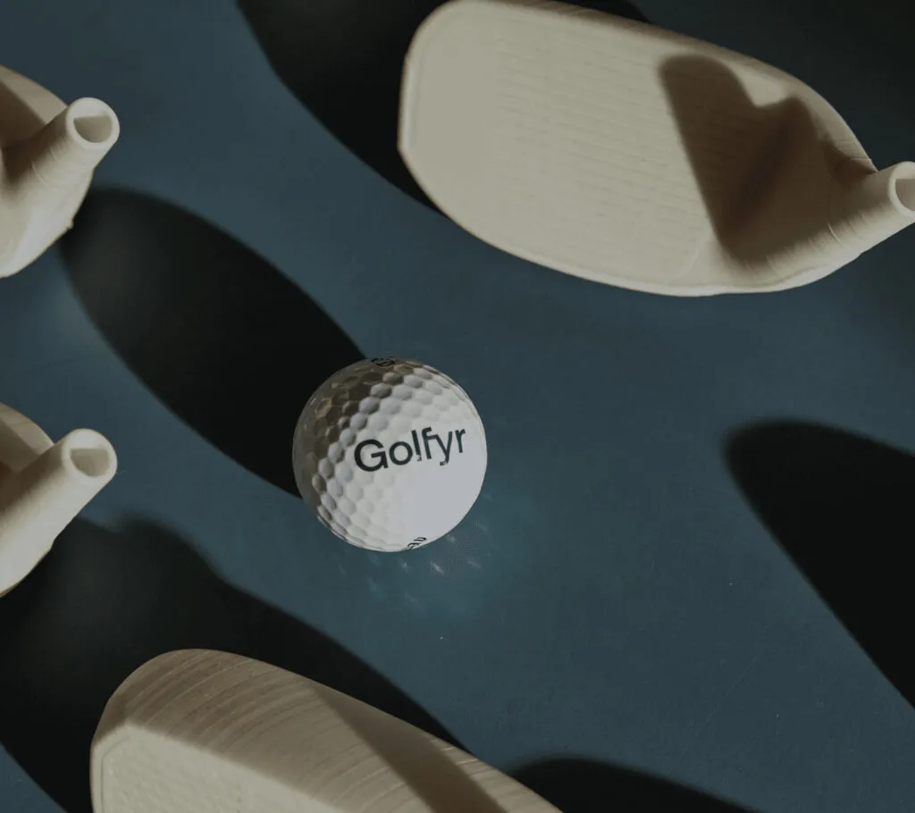 Auslegeordnung von verschiedenen Prototypen und einem Golfball mit Golfyr Logo.